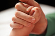 Baby holding mother's hand.