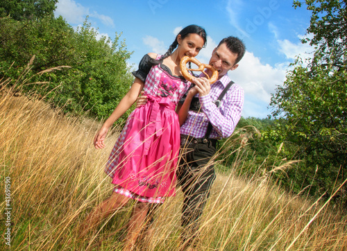 Photo: Fröhliches Bayerisches Paar mit Lederhosen und Dirndl Fröhliches Bayerisches Paar mit Lederhosen und Dirndl