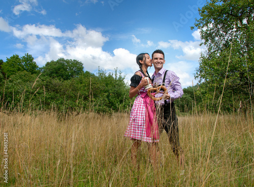 Foto: Fröhliches Bayerisches Paar mit Lederhosen und Dirndl Fröhliches Bayerisches Paar mit Lederhosen und Dirndl