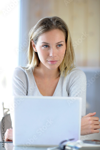 Foto : Woman sitting in front of laptop computer Woman sitting in front of laptop computer