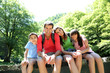 Portrait of family sitting on a bridge in forest