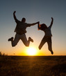 Young happy couple jumping high in the air