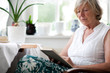Seniorin lesend im Sessel