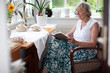 Seniorin lesend im Sessel
