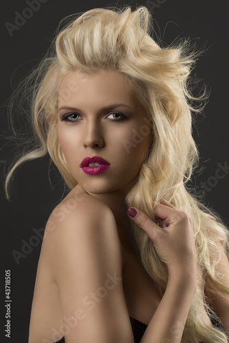 Photo: beauty portrait of blonde girl she touches a lock of hair beauty portrait of blonde girl she touches a lock of hair