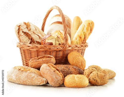Photo: Bread and rolls in wicker basket isolated on white Bread and rolls in wicker basket isolated on white