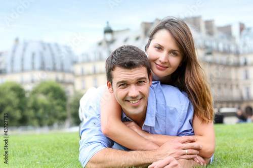 Photo: In love couple laying in public park In love couple laying in public park