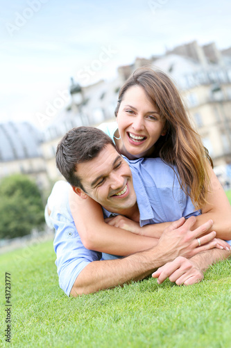 Foto: In love couple laying in public park In love couple laying in public park