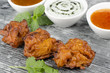 Onion Bhajis, mango chutney, mint raita & chili sauce on a slate