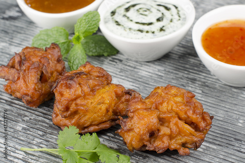 Photo: Onion Bhajis, mango chutney, mint raita & chili sauce on a slate Onion Bhajis, mango chutney, mint raita & chili sauce on a slate