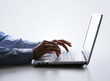 Silhouette of male hands typing on a laptop