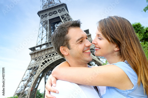 Foto: Romantic couple kissing by the Eiffel Tower Romantic couple kissing by the Eiffel Tower