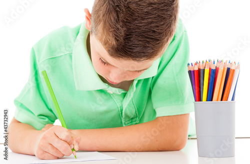 Photo: Schoolboy drawing with a pencil on white background Schoolboy drawing with a pencil on white background