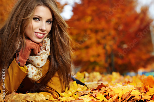 Photo: Portrait of very beautiful young woman in autumn park Portrait of very beautiful young woman in autumn park