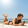 Frau mit Smartphone am Strand
