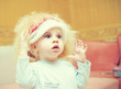the kid in a wig and with cosmetics on a face