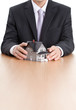Foto: Businessman hands around home architectural model Businessman hands around home architectural model