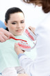 Dentist and his assistant teach the patient how to clean teeth