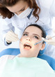 Dentist's assistant checks up the dentes of the patient