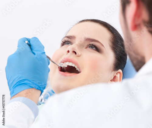 Photo: Dentist examines teeth of the patient on the dentist's chair Dentist examines teeth of the patient on the dentist's chair