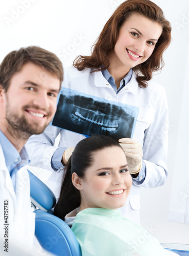 Photo: Dentist, assistant and client are satisfied of their work Dentist, assistant and client are satisfied of their work