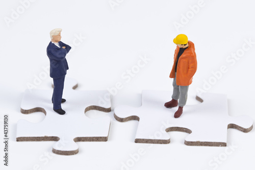 Photo: Zwei Miniaturfiguren auf einem Puzzle Zwei Miniaturfiguren auf einem Puzzle