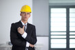 Businessman with yellow helmet poses and hand gesture