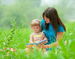 Photo: mother and daughter reading book together outdoor mother and daughter reading book together outdoor