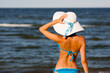 Sexy girl in big hat on the beach
