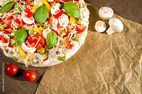 Photo: Close-up of fresh pizza lying on the baking paper Close-up of fresh pizza lying on the baking paper