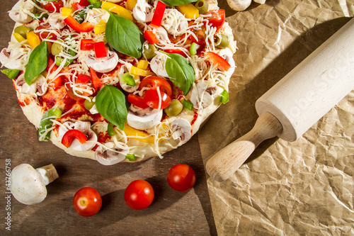 Photo: Rolling pin and fresh pizza Rolling pin and fresh pizza