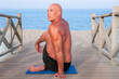 Photo: Man practising Yoga at the beach Man practising Yoga at the beach