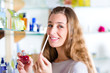 woman buying perfume in shop or store