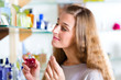 woman buying perfume in shop or store