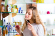 woman buying perfume in shop or store