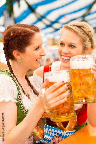 Photo: Junge Frauen in traditionellem Dirndl in Bierzelt Junge Frauen in traditionellem Dirndl in Bierzelt