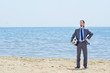 Businessman with football on beach