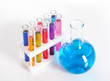 Group of test tubes in a rack and a flask with colored liquid