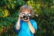 Young beautiful photographer with a camera shoots you outdoors