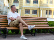 Man sitting waiting on an urban bench