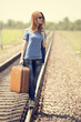 Young fashion girl with suitcase at railways.