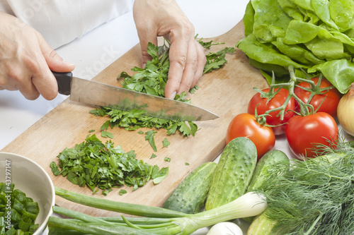 Photo: Cook in the kitchen at work preparing vegetable salad Cook in the kitchen at work preparing vegetable salad