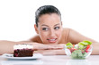 Photo: woman choosing between healthy food and tasty cakes woman choosing between healthy food and tasty cakes