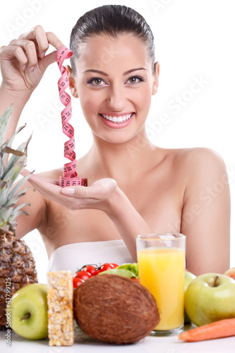 Photo: Woman with healthy food and measuring tape Woman with healthy food and measuring tape