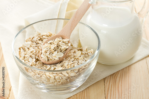 Foto: Oat flaks on a glass bowl and jug of milk Oat flaks on a glass bowl and jug of milk