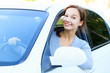 Pretty girl in a car smiling to you