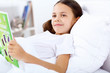 Photo: Girl with a book in bed at home Girl with a book in bed at home
