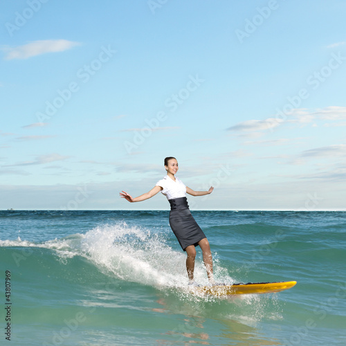 Photo: Young business person surfing on the waves Young business person surfing on the waves