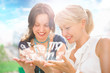 Two women mother and daughter sitting at summer park and having