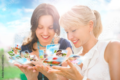 Photo: Portrait of two happy women mother and daughter looking their ph Portrait of two happy women mother and daughter looking their ph